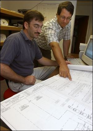 David Dmytryka, right, president of Dmytryka Jacobs Engineers Inc. of Perrysburg Township, goes over plans of a water treatment plant with Michael Beeman, project manager.