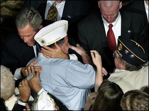Members of the American Legion embrace President Bush in Nashville yesterday.