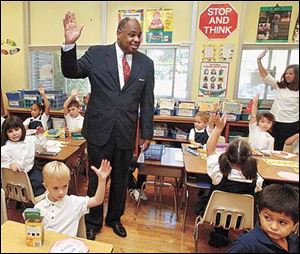 Eugene Sanders, superintendent of Toledo Public Schools, asks first graders at Harvard Elementary how many of them will be coming back for the second day of classes.