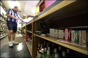 Dennis Gutman rings up a sale at Clip's carryout, where the stock of cigarettes was never large but has gotten smaller.