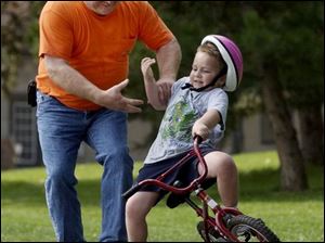 ROV September 15, 2004 - Tom Clapsaddle grabs the arm of his grandson Andrew Horton, 5, who started to fall while learning to ride a bicycle in Toledo's Walbridge Park Wednesday afternoon.  (Also helping but not in photo is Mary Clapsaddle, Andrew's grandmother and Tom's wife.)  Blade photo by Dave Zapotosky