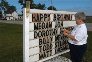 Helen Gillen updates her sign that is designed to make those passing by a little bit happier. She has a master list that includes more than 2,400 names for birthdays and anniversaries.