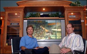 Ric Clark and David Jamieson display at their store at 5421 Monroe St. one of the theater-style home entertainment centers that are popular with customers nowadays. 