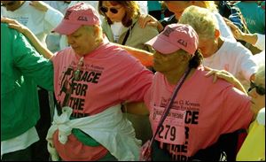 Cty  race19p  Downtown Toledo  by Fifth Third  Field.  Race for the cure.   Starting line  - walkers  pray and link arms before the race and walk. .    Diane Hires  9/19/04