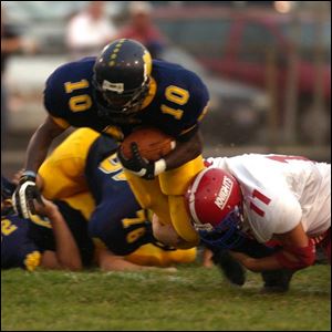 Whitmer's Justin Meyer is tackled by Chris Ceparski of St. Francis, who also recovered two fumbles, after gaining a few yards.