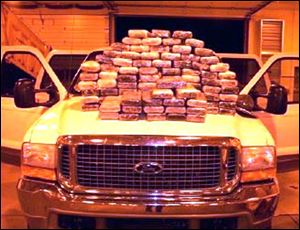 Troopers stack on a Ford Excursion they stopped along the turnpike the 90 kilos of cocaine they allegedly found inside it.
