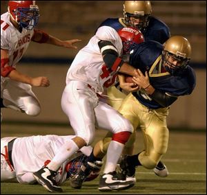 St. Francis defender Brandon Kulka tries to strip the ball from St. John's running back Rusty Marvin in the Glass Bowl.