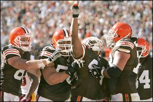 Lee Suggs (arm raised) is mobbed by his teammates after scoring the game-winning touchdown to cap an 80-yard drive.