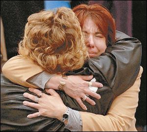 Stephanie Armstrong, former sister-in-law to jack Armstrong, the construction engineer who was beheaded in Iraq last month, hugs friend Gina Valdez, left at a memorial service in Hillsdale yesterday.
