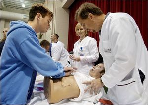 CTY October 6, 2004 - Jesse Szych, 16, a sophomore at North Baltimore High School,  learns how to clear an object from the throat of an unconscious choking victim from Tom Koehl, right, a nursing student at Owens Community College, during Care Fair for Health 2004.  Owens nursing student Lorie Cupp, center, looks on.  The fair, attended by more  than 500 high school students,  took place in the Student Health and Activities Center at Owens on Wednesday.   Blade photo by Dave Zapotosky  fair06p