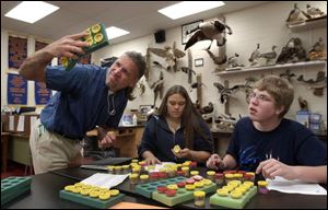 Charlie Schneider helps students Nistasha Bradfield, 15, and Jim McGill, 17, identify seeds during agriculture class at Clay High School. Mr. Schneider recently won an award as top agriculture teacher in Ohio.