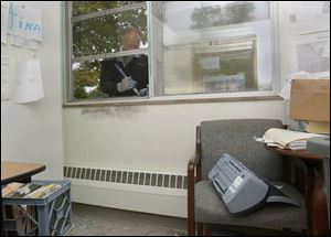 Glass Doctor worker Tim Born repairs the broken window in Tina Skeldon Wozniak's office at the Democratic Headquarters in Toledo today.
