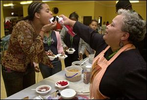 CTY SUNDAE11P 10/11/04 PHOTO BY LORI KING Robinson Jr. Hi 7th grader Moranda Smith gets rewarded for her satisfactory report with a mouth full of whip cream, courtesy of teacher Linda Watson, during sundae treats for all students who received S reports.