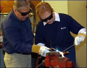 Robert Feduik shows Terra Community College President Marsha Bordner how to braze metal pipes together with an oxyacetylene torch. Ms. Bordner was taking a hands-on look at the college's heating, ventilating, and air conditioning repair program.