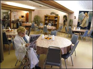 Margie Cereghin reads the paper after lunch at the Defiance Senior Center. Former Director Diana Mayer faces accusations of improperly spending more than $40,000 of the center's funds.