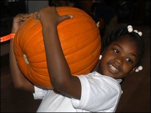 Cty pumpkin20p 2 .jpg  Jordan Flower 7, with her  pumpkin at the Erie street market pumpkin hunt. blade photo by herral long 10/20/2004