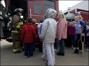 NBR swanfire14p A  Oct. 14, 2004-- Swanton firefighter and EMT Gary Roytek shows Crestwood Elementary students a fire engine during a tour of the station Thursday. The event was part of Fire Safety Awareness Monday. Blade photo by Andy Morrison