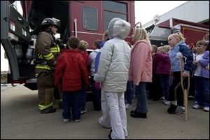 NBR swanfire14p A  Oct. 14, 2004-- Swanton firefighter and EMT Gary Roytek shows Crestwood Elementary students a fire engine during a tour of the station Thursday. The event was part of Fire Safety Awareness Monday. Blade photo by Andy Morrison