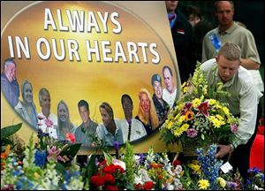An employee places flowers at a memorial site at the Hendrick Motorsports headquarters in Concord, N.C.