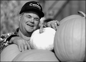 Walter Keil, of Louis Keil Jr. & Sons farm, displays a white pumpkin nestled among traditional orange ones.