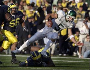 Michigan State QB Drew Stanton is tripped up by Michigan's Gabriel Watson. Stanton left the game with a separated shoulder.