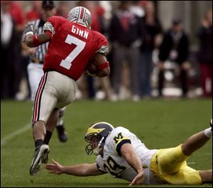 Ohio State's Ted Ginn Jr. steps past Michigan punter Adam Finley on his 82-yard punt return for a touchdown in the third quarter.