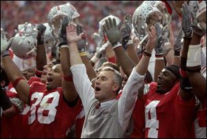 OSU coach Jim Tressel, center, sings 'Carmen Ohio' after the victory over Michigan with players Branden Joe, left, and Santonio Holmes.