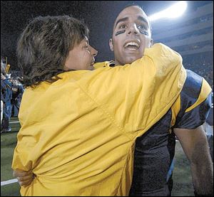 A Rockets fan gives quarterback Bruce Gradkowski a hug after UT defeated rival Bowling Green 49-41 on Tuesday night at the Glass Bowl. Gradkowski passed for 338 yards and two TDs.