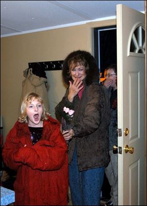 Emily, left, Kathleen, and Brendan Vilfroy react as they enter their refurbished home.