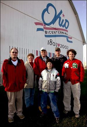 The bicentennial logo provides a backdrop for the Lowe family: Michael, left, Brenda, Jim, Johnny, Brian, and Jimmy. The Ottawa County barn has been in the family since 1930.