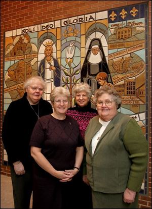 Sisters Justine Hill, from left, Donna Frey, Nelda Chafitelli, and Kathleen Padden stand in front of the new mosaic that depicts the history of the Toledo group of Ursulines. 