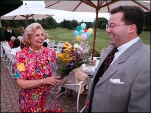 Steven Ambrose, right, surprises Toledo philanthropist Ann Galloway at a birthday party for her at Inverness Club in 1997. Ambrose would enter clubs and events claiming to be Mrs Galloway's nephew. Mrs. Galloway now says Ambrose 'seemed to prey on women who were older.'