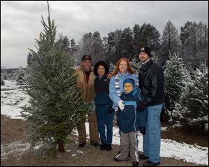 A.J. Nye, 10, with his mother, Allison Irons, and father, Adam Nye, pick out a Christmas Tree with Duke Wheeler, left, and his wife, Martha, owners of the Whitehouse Christmas Tree Farm. 