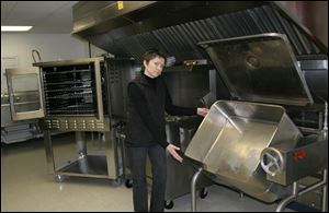 Co-manager Jenni Hirzel demonstrates the tilting brazier; at left is one of the two convection ovens.