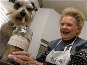 Janice Ferguson gives her dog Monte a sample of the canine snacks she makes at the cooperative kitchen. 