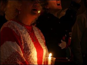 cty christmaseve24p 1 December 24, 2004. Left Betty Koprowski of Oregon, O., and her daughter-in-law Kim Koprowski of Luckey, O., sing "Silent Night" during a Christmas Eve service at CedarCreek Church. Blade photo by Jeremy Wadsworth