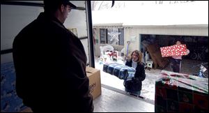 Jamie Crothers awaits gifts to be stacked as his wife Joni and their daughter Lara ferry wrapped parcels to the truck.