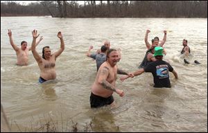 Cold but elated swimmers celebrate their New Year s Day dip in the Maumee River.