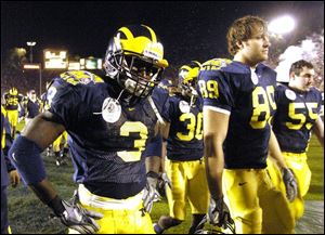 Michigan's Marlin Jackson (3), Tyler Ecker (89) and Jeremy Read (55) walk off the field after a Rose Bowl defeat.