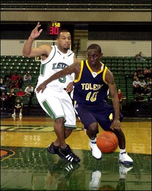 Rockets guard Kashif Payne slips around Eastern Michigan's Michael Ross during the first half yesterday. Payne scored six points for UT in the opening game of Mid-American Conference play.