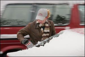 Monica Witing of Port Clinton put the scraper to her car.