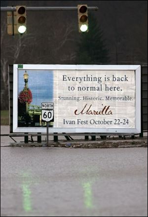 A billboard in Marietta, Ohio, was intended to assure residents after the remnants of Hurricane Ivan swept through the area that life was back to normal. More flooding has hit the city.