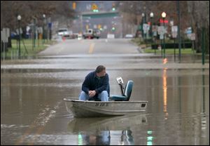 Joe Pilkington waits for help in his boat on First Street in Marietta, Ohio, where the Ohio River crested 9 feet above flood level.