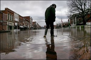 John Bolen, owner of a shoe shop in Marietta, Ohio, surveys the flooding that damaged about 200 businesses. 