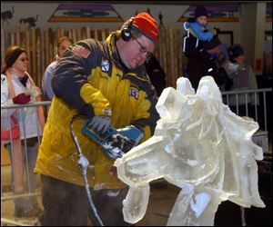 Visitors watch professional carver Robert Childers of Illinois as he works on his sculpture during the competition at the Toledo Zoo. The works can be viewed as long as the weather holds.