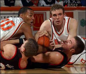 BG's Mawel Soler, left, and John Reimold fight for a loose ball with the Huskies' Paige Paulsen, bottom left, and Todd Peterson.