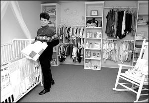 Sheri Phillips, publicity director, organizes items in the Pregnancy Center of Greater Toledo's 'Baby Boutique.'