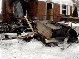 CTY fire25p -   Interior items from the home at 1637 Travis Dr. in Toledo remain on the front lawn after a flammable object was thrown through the living room window early Wednesday morning January 26, 2005.  The Blade/Madalyn Ruggiero