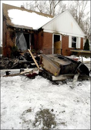 CTY fire25p -   Interior items from the home at 1637 Travis Dr. in Toledo remain on the front lawn after a flammable object was thrown through the living room window early Wednesday morning January 26, 2005.  The Blade/Madalyn Ruggiero