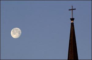 ROV Full Moon -- A nearly full moon sets past the steeple at St. Paul's Lutheran Church on Erie Street, Thursday, 01/27/05. The Blade/Andy Morrison